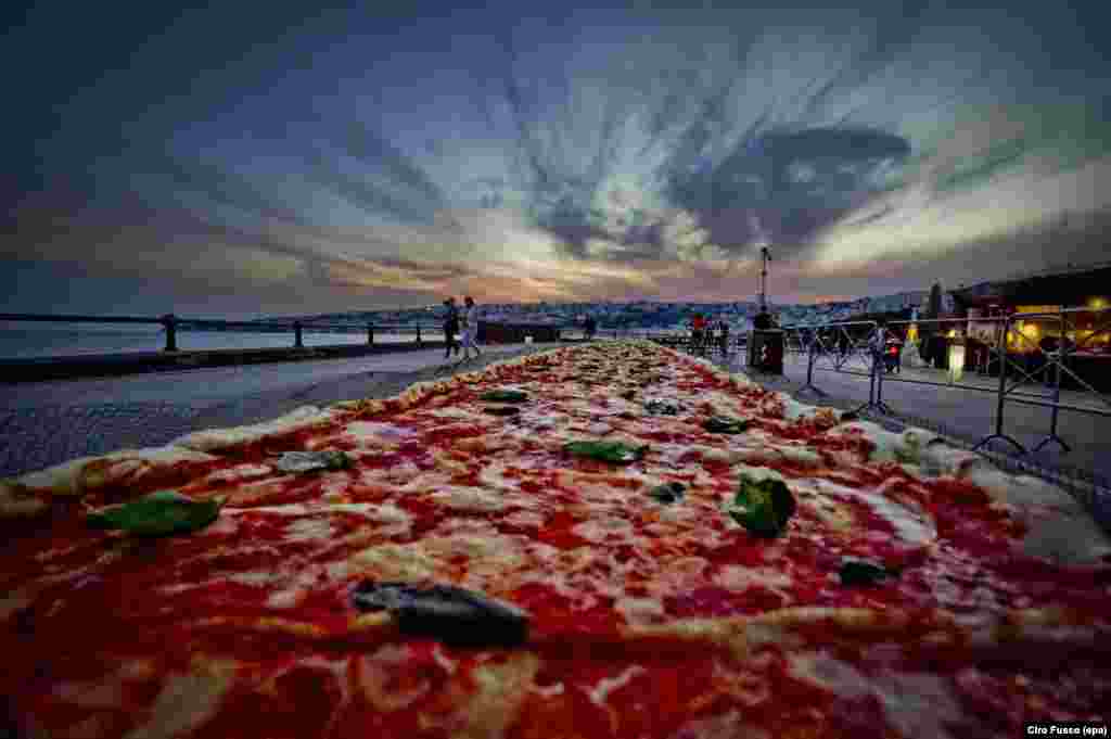 A two-kilometer long Neapolitan pizza — made to break a Guinness World Record for the longest pizza ever made — is seen stretching along the city waterfront, in Naples, Italy, May 18, 2016.