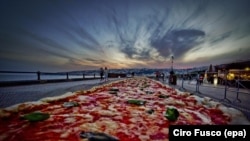 A general view of a Neapolitan pizza made to break the world record for the longest pizza ever made, by making a two kilometers margherita (16 inch wide) pizza stretching along the city waterfront, in Naples, Italy, 18 May 2016.