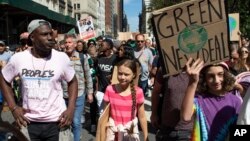 Swedish environmental activist Greta Thunberg, center, takes part during the Climate Strike, Friday, Sept. 20, 2019 in New York. Rallies calling for action on climate change are happening in cities around the world Friday. (AP Photo/Eduardo Munoz Alvarez)