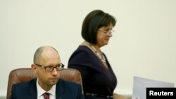 FILE - Ukrainian Finance Minister Natalia Yaresko (R) walks past Prime Minister Arseny Yatseniuk during a government meeting in Kyiv.