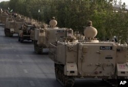 FILE - Pakistani army troops ride military vehicles following an operation launched against the Taliban in North Waziristan, in Karachi, Pakistan, June 16, 2014.