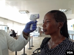 A passenger gets screened while departing Lungi airport, Freetown, Sierra Leone, Feb. 3, 2015. (Nina deVries/ VOA)