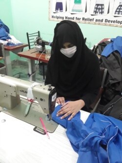 خواتین کے تربیتی مرکز میں ایک خاتون ماسک تیار کر رہی ہے۔