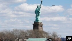 Polisi New York melakukan pemeriksaan di lokasi patung Libery, Jumat (24/4).