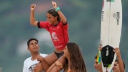 Luana Reis, 14, is carried atop the shoulders of friends after winning the under-18 category of a local surf tournament in Maresias beach, Sao Sebastiao, Brazil, Nov. 26, 2021.