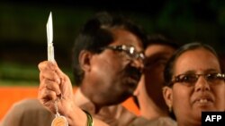 Seorang perempuan India memegang pisau sambil berfoto dalam acara yang diselenggarakan oleh partai nasionalis Hindu India, Partai Shiv Sena, di Mumbai, 23 Januari 2013. Shiv Sena memberikan pisau sebagai alat bela diri sebagai hadiah ulang tahun mendiang pendirinya Bal Thackeray.