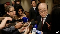 FILE - China's Ambassador to the U.N. Liu Jieyi, right, takes questions from the media during a break in United Nations Security Council consultations.