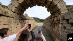 School students use a mobile app at the ancient site of Olympia, southwestern Greece, Wednesday, Nov. 10, 2021. (AP Photo/Thanassis Stavrakis)