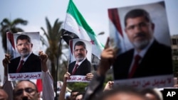 Supporters hold posters of Egypt's Islamist President Mohammed Morsi during a rally near Cairo University Square in Giza, Egypt, Tuesday, July 2, 2013. Egypt was on edge Tuesday following a "last-chance" ultimatum the military issued to Mohammed Morsi, gi