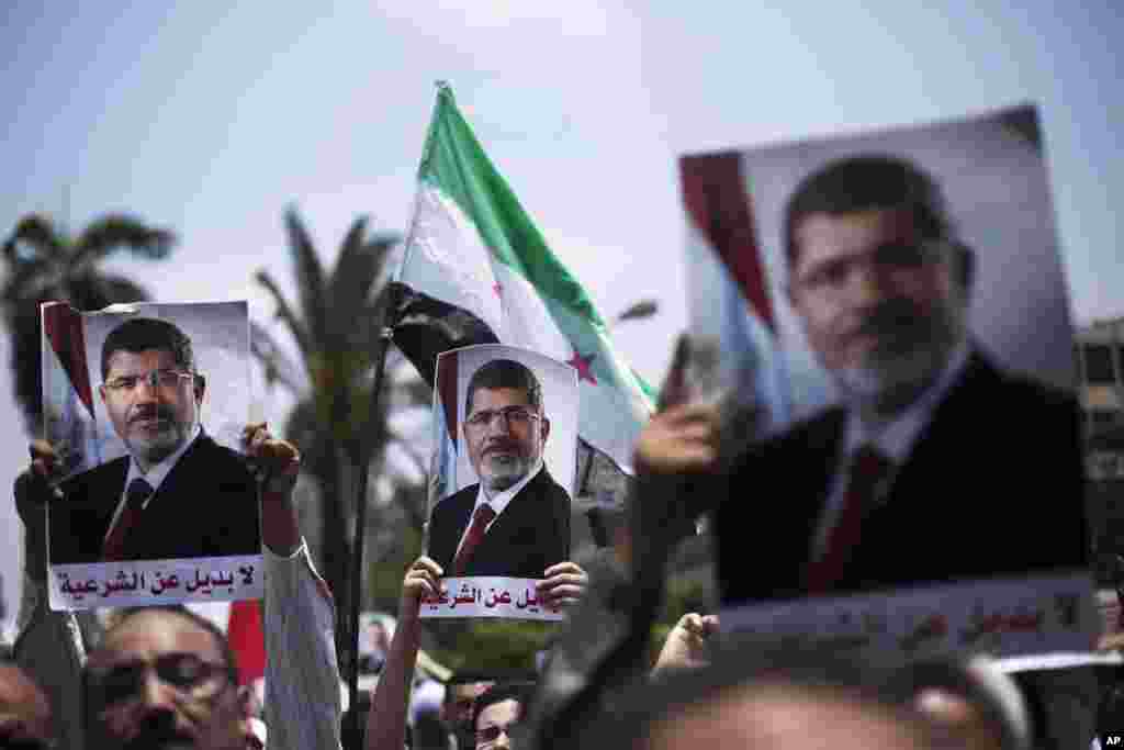 2일 이집트 기자에 위치한 카이로대학 인근 광장에서 무르시 대통령 지지자들이 포스터를 들고 행진하고 있다.