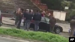 People gather where witnesses say a shooter was arrested in Macerata, Italy, Feb. 3, 2018, in this still image obtained from social media video. (Marcelo Mancini via REUTERS)