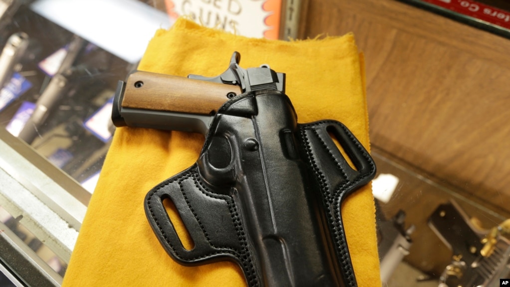 Una pistola semiautomática y un porta-pistolas se exhiben en una tienda de armas de Little Rock, Arkansas. Foto de Archivo. 