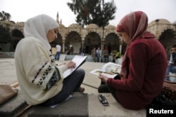 Youths read and draw in the Ottoman-era Tekkiye Suleimaniye mosque complex in Damascus, Syria, March 2, 2016.