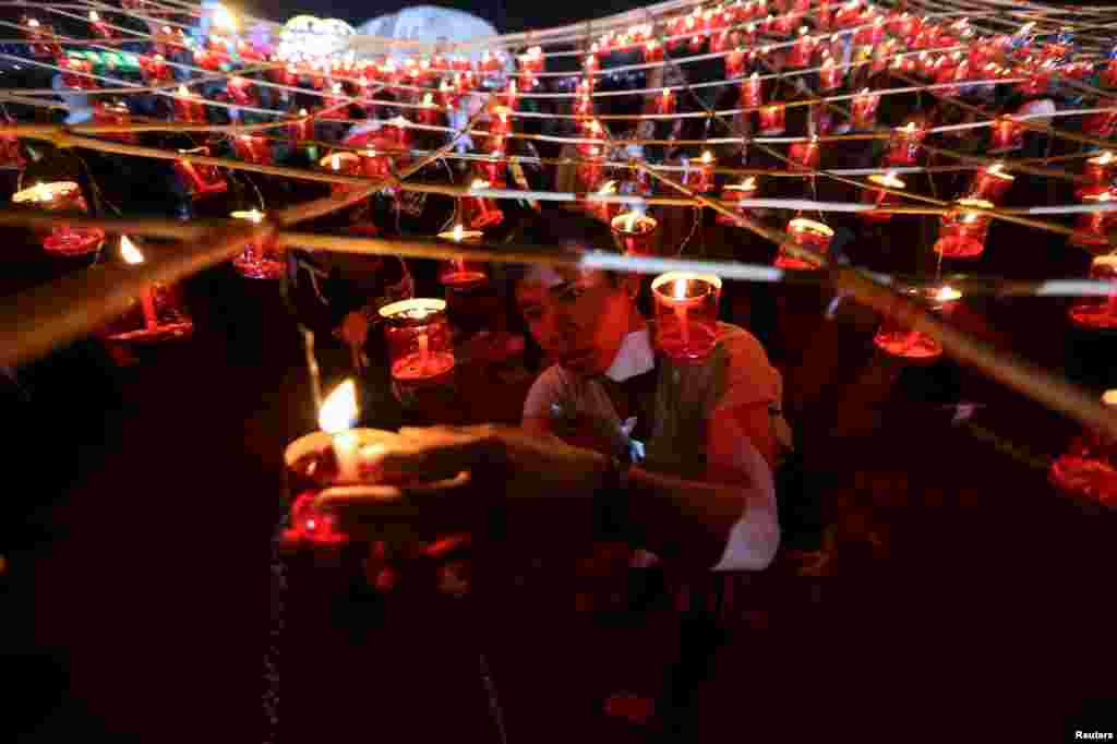 Orang-orang menyalakan lilin sebelum melepaskan balon kertas ke angkasa pada festival tahunan Tazaungdaing di Taunggyi, Myanmar.