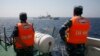 Vietnamese Marine Guard officers monitor a Chinese coast guard vessel on the South China Sea, about 210 km (130 miles) offshore of Vietnam, May 15, 2014.