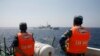 FILE - Officers of the Vietnamese Marine Guard monitor a Chinese coast guard vessel, top, on the South China Sea, about 210 km (130 miles) offshore of Vietnam, May 15, 2014.