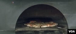 Inmates at the Cook County Jail in Chicago make pizza under the watch of Bruno Abate.