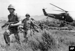 FILE - In this April 28, 1965 file photo, U.S. Marine infantry stream into a suspected Viet Cong village near Da Nang in Vietnam during the Vietnamese war. Filmmaker Ken Burns said he hopes his 10-part documentary about the War, which begins Sept. 17, 201