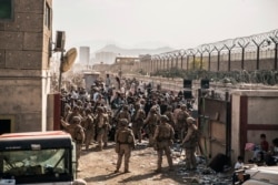 Marinir AS memberikan bantuan di pos pemeriksaan kontrol evakuasi selama evakuasi di Kabul, Afghanistan. (Foto: via AP)