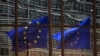 A European Union flag reflects on a building of EU headquarters in Brussels. The EU announced on Thursday, July 10, 2014 that it is imposing sanctions on South Sudanese officials who it says have been obstructing peace.