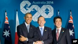 El presidente Barack Obama, y los primeros ministros, Tony Abbott, de Australia, y Shinzo Abe, de Japón, se entrelazan al inicio de su reunión tripartita en Brisbane, Australia.