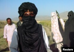 افغانستان میں خانہ جنگی کے دوران طالبان پر غیر ملکی افراد کو یرغمال بنائے جانے کے الزامات لگتے رہے ہیں۔ 2007 کی اس تصویر میں بین الاقوامی ریڈکراس کمیٹی کا ایک رکن وردک صوبے میں طالبان کی جانب سے آزاد کیے جانے والے ایک شخص کے ساتھ کھڑا ہے۔