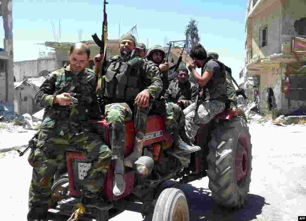 Syrian army soldiers with their weapons in the city of Qusair, June 5, 2013.