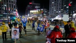 한국 국회의원 선거유세 종료 하루 전인 12일 밤 경기도 고양시 화정역에서 국회의원 후보 운동원들이 마지막 유세를 벌이고 있다.