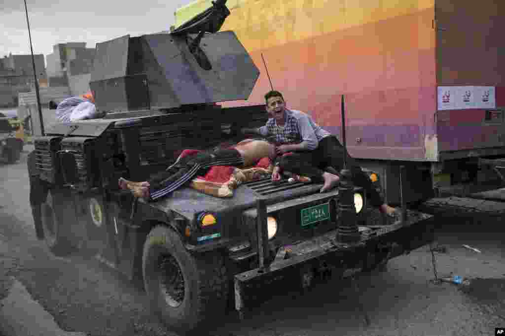 An injured man is carried atop an Iraqi special forces armored vehicle during fighting against Islamic State militants in western Mosul.