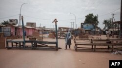 Un homme se tient au milieu d'un barrage de fortune, dans le quartier musulman du PK5 de Bangui, le 9 avril 2018.