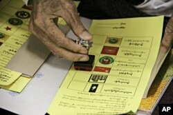 A man stamps his early ballot at Hnin Si Kone Old Aged Center Nov 6, 2015, in Yangon, Myanmar.