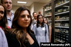 In this June 27, 2019 photo, family members of former U.S. Secret Service chief chemist Antonio Cantu tour an International Ink Library that was named in remembrance of Cantu at the Secret Service headquarters building in Washington, DC.