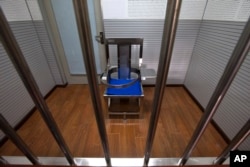 FILE - A chair specially designed to restrain inmates is seen behind bars in an interrogation room at the Number One Detention Center in Beijing, Oct. 25, 2012. Rights activists suspect that many of the disappeared might be subjected to torture.