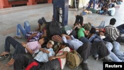 People from India's northeastern states, take a nap at a platform while waiting for the train to board back to their homes at a railway station in the southern Indian city of Chennai, August 17, 2012.