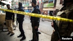 Security officials cordon off the site of a Taliban suicide blast that killed 10 people in a crowded market near the Pakistani army headquarters in the tribal region of North Waziristan in Rawalpindi, Pakistan, Jan. 20, 2014.