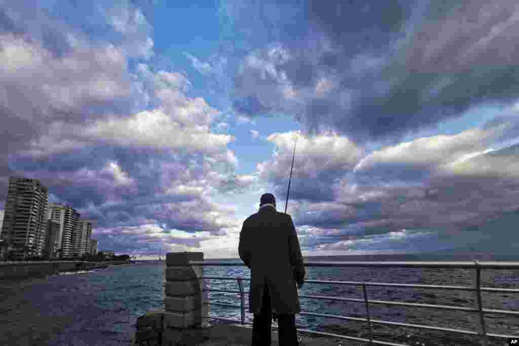 یک مرد مشغول ماهیگیری در ساحل دریای مدیترانه در بیروت، لبنان