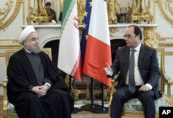 French president Francois Hollande, right, speaks with Iranian President Hassan Rouhani during a meeting at the Elysee Palace, in Paris, Jan. 28, 2016.