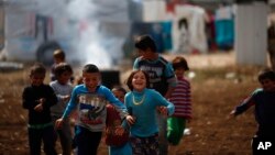 Syrian refugee boys play at a refugee camp in the town of Hosh Hareem, in the Bekaa valley, east Lebanon, October 28, 2015.