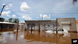 A car and homes are submerged in floodwater in Concordia, Argentina, Dec. 28, 2015. 