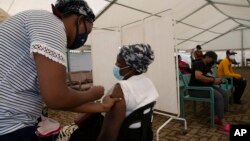 Petugas memberikan vaksinasi COVID-19 kepada warga di Soweto, Afsel (29/11). Bukti baru mengungkapkan varian omicron sudah ada di Eropa Barat jauh sebelum terdeteksi di Afrika Selatan.