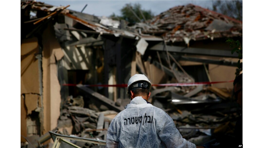 Seorang petugas kepolisian Israel memeriksa kerusakan sebuah rumah yang dihantam roket di Mishmeret, Israel tengah, 25 Maret 2019