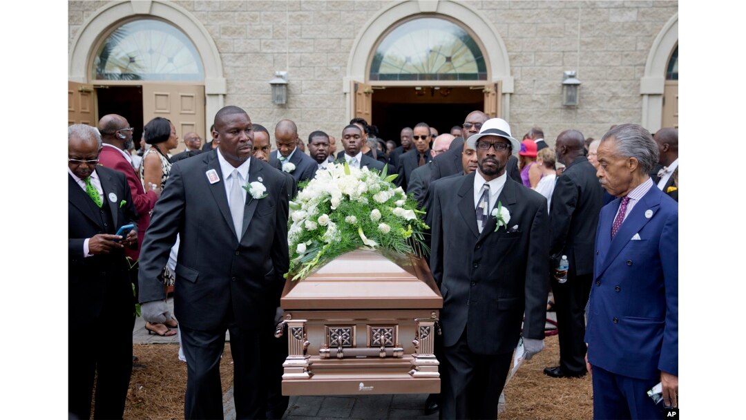 The Rev. Al Sharpton (R) watches as the casket of Ethel Lance is carried to a hearse following her funeral service, June 25, 2015, in North Charleston, S.C.