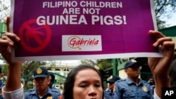 A Mother displays a placard during a rally outside the Department of Health to protest the administration of the anti-Dengue vaccine Dengvaxia which was developed by Sanofi Pasteur, Feb. 7, 2018, in Manila, Philippines.