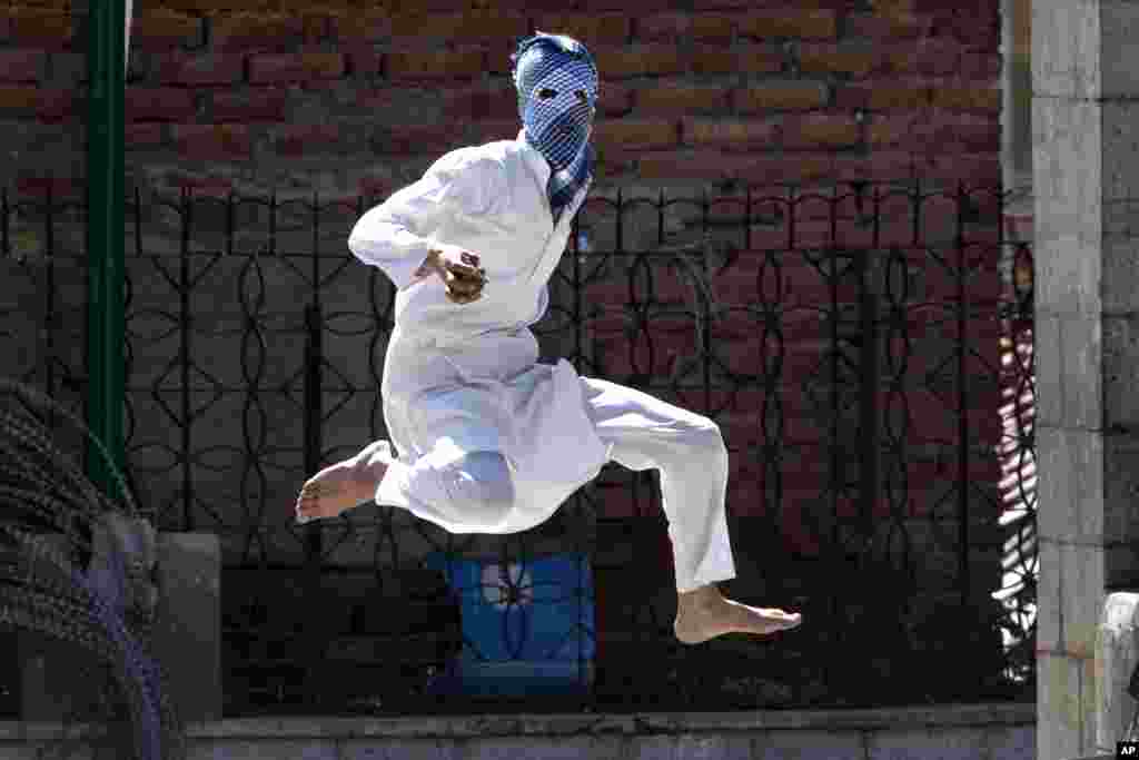 A Kashmiri Muslim protester jumps in the air to avoid stones thrown at him by Indian police during a protest in Srinagar, Indian-controlled Kashmir. Government forces fired tear gas and pellet guns to stop rock-throwing Kashmiri youths after Friday prayers.
