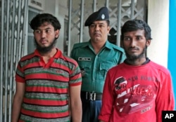 A Bangladeshi policeman escorts Jikrullah, left, and Ariful Islam, suspects in the hacking death of blogger Washiqur Rahman Babu, in Dhaka, March 30, 2015.