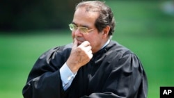 FILE - In this 2006 photo, Supreme Court Justice Antonin Scalia listens to President Bush speak during a ceremony at the White House.