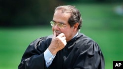 FILE - In this 2006 photo, Supreme Court Justice Antonin Scalia listens to President Bush speak during a ceremony at the White House.