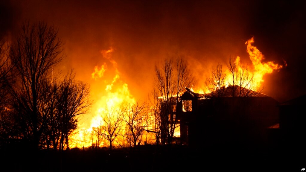 Homes burn as wildfires rip through a housing development, Dec. 30, 2021, in Superior, Colorado.