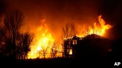 Homes burn as wildfires rip through a housing development, Dec. 30, 2021, in Superior, Colorado.