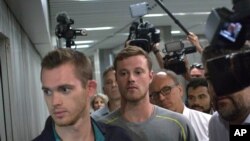 Gunnar Bentz e Jack Conger deixando a estação da polícia no aeroporto